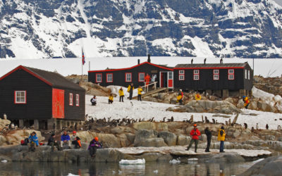 A group of people standing on top of a snow covered mountain.