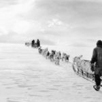 A group of people walking in the snow.
