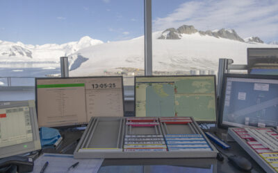 The view from a desk looking out of a window towards a snow capped mountain